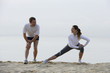 © Alexander - Couple stretching on beach