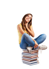 young girl sitting on a books tower isolated on white