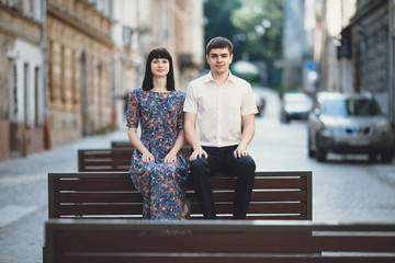 Wall Mural - Funny couple is sitting on the wooden bench