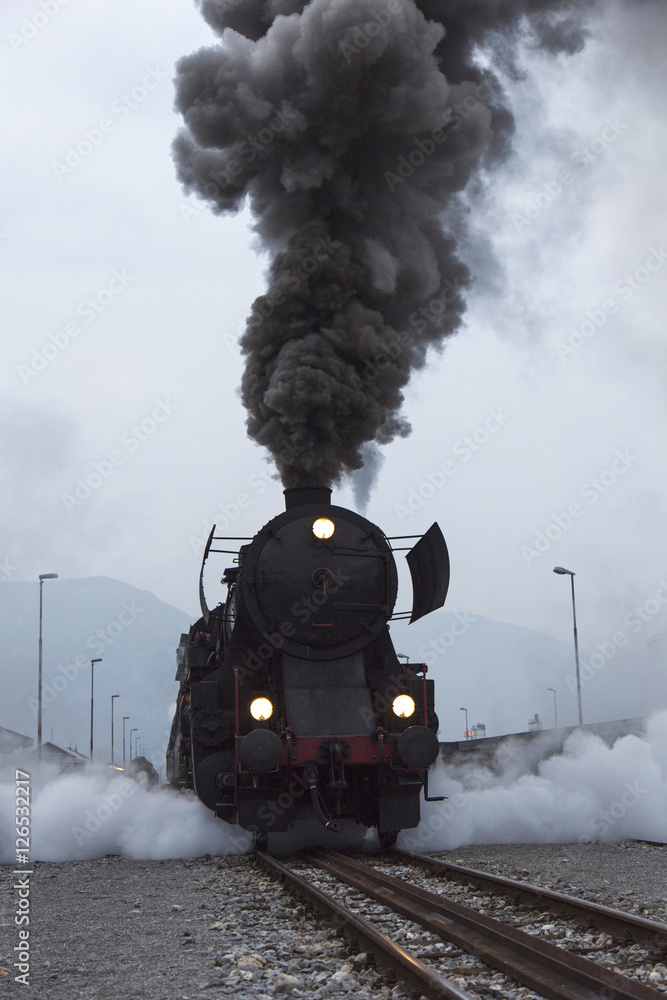 Old Steam Locomotive driving and leaving smoke and vapour - obrazy, fototapety, plakaty 