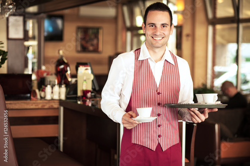 Zdjęcie XXL Portret szczęśliwa młoda kelner pozycja w kawiarni