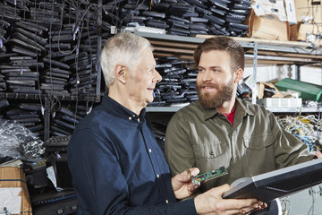 People working in storage of computer recycling plant