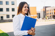 © newagecinema - beautiful businesswoman with a folder in front of office