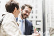 © Westend61 - USA, New York City, smiling businessman and woman with cell phone