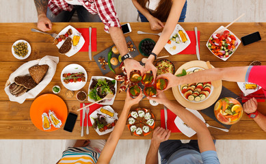 Wall Mural - People say cheers clink glasses at festive table dinner party