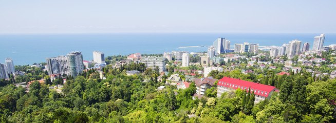 Wall Mural - The small town is on the background of the mountain range, the landscape. City, mountain and blue sky are in Russia, Sochi. 