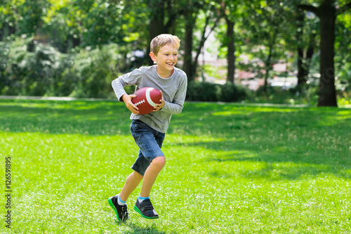 Plakat Chłopiec bieganie z piłką rugby
