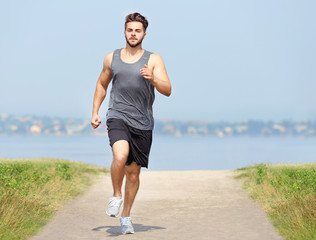 Wall Mural - Man jogging on river background