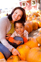 Happy Family Picking Pumpkins At The Pumpkin Patch.