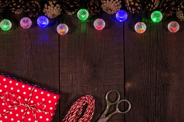 Christmas garland, box and cones on the wooden background.