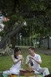 © Alexander - Singapore, Couple on picnic blanket opening wine