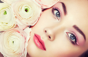 Wall Mural - Portrait of beautiful young woman with flowers. Brunette woman with luxury makeup. Perfect skin. Eyelashes. Cosmetic eyeshadow