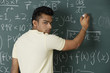 © Alexander - young man writing formulas on chalk board