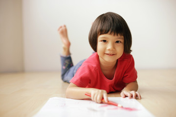 Young girl drawing, looking at camera