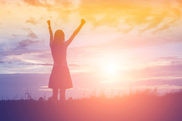 Silhouette of woman praying over beautiful sky background