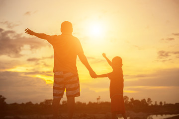 Happy dad throws the baby at sunset