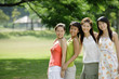 © Alexander - Young women standing side by side, smiling at camera