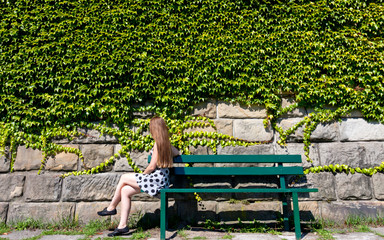 Girl on the bench in the garden