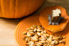 Pumpkin and pumpkin seeds on an orange plate