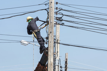 Electrician connects wires on a pole