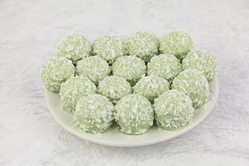 delicious green coconut candies on white plate on  white backgro