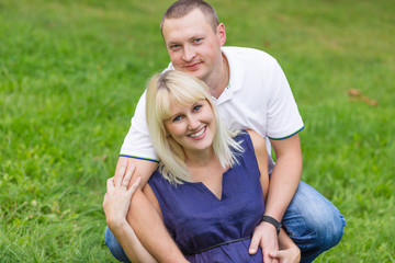 Young pregnant mother with her family in a park