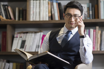 young businessman reading book in his study