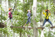 © Blue Jean Images - Happy children playing in tree top adventure park