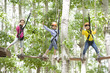 © Blue Jean Images - Happy children playing in tree top adventure park