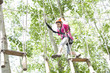 © Blue Jean Images - Little girl playing in tree top adventure park
