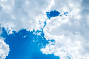 Wall Mural - looking up at big white cloud and light ray behind cloud with bl