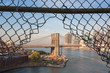 Brooklyn Bridge framed in a hole in a fence