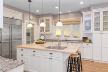 Amazing Luxury Kitchen Interior In White With Wooden Floor And Kitchen Island.