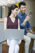 © Blue Jean Images - Business people using a laptop and mobile phone while sitting
