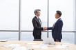 © Blue Jean Images - Businessmen shaking hands in meeting room