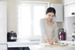 © Blue Jean Images - Young woman kneading dough on cutting board