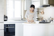 © Blue Jean Images - Smiling young woman making cookies in the kitchen