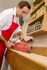 Wall Mural - Close up of butcher cutting meat