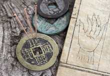 Acupuncture Needles Beside An Old Medicine Book And Antique Coins