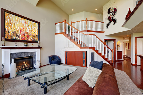 American Living Room With High Vaulted Ceiling And Staircase