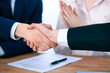 © rogerphoto - Business people shaking hands finishing up a meeting