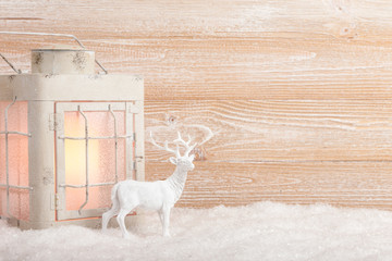 Poster - Christmas background with candle lantern and reindeer on snow