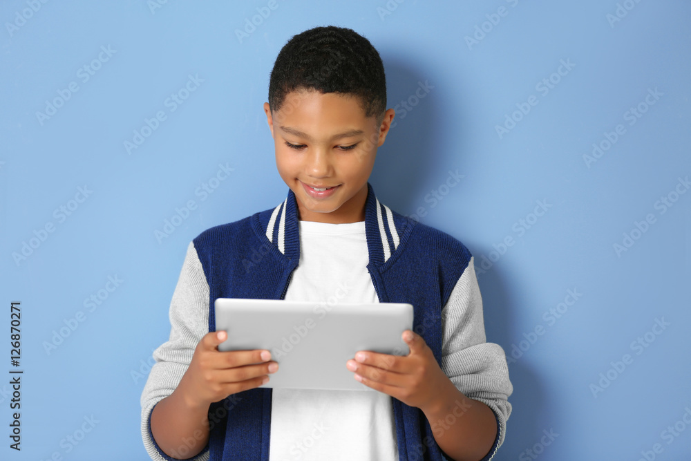 African American boy with tablet on blue background