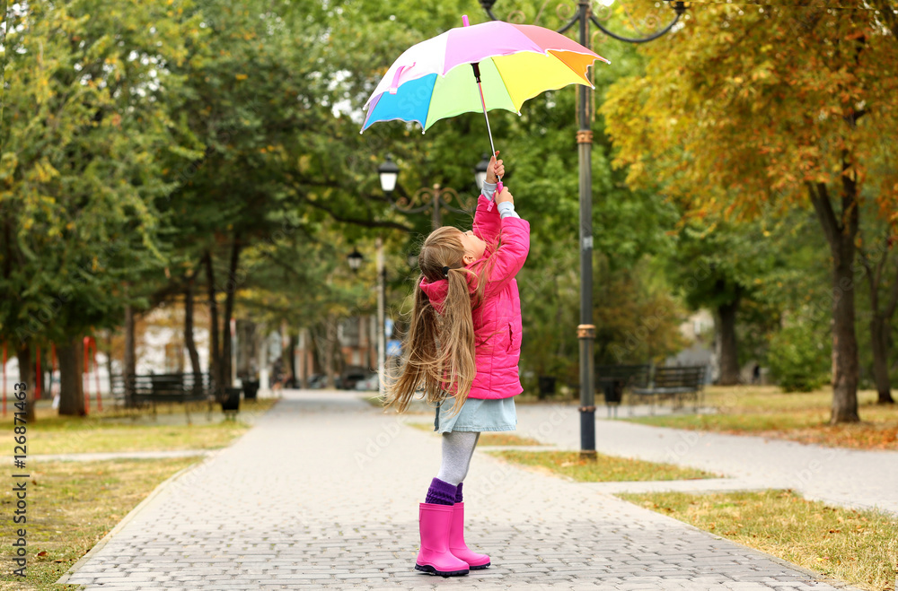 Cute girl with colorful umbrella in park