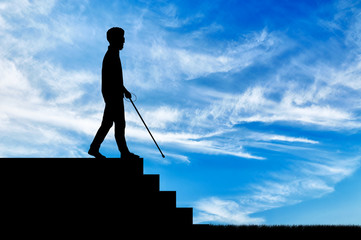 Blind disabled person with cane on stairs goes down day