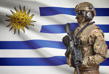 Soldier in helmet holding machine gun with flag on background series - Uruguay