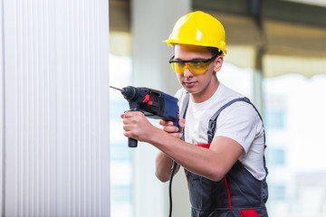 Wall Mural - Man drilling the wall with drill perforator