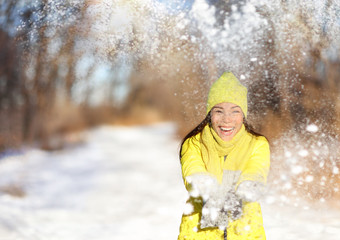 winter snow fight happy girl throwing snow playing outside. joyous young asian woman having fun in n