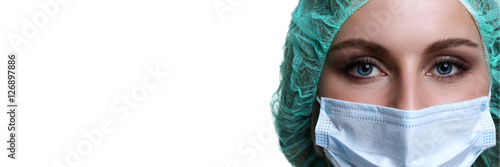 Fototapeta na szkło Kobiety doktorska twarz jest ubranym maskę ochronną i zieloną chirurg nakrętkę