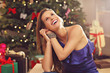 © Kalim - Happy woman sitting over Christmas tree